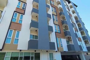 Un edificio residencial de varios pisos con balcones, ventanas amplias y un diseño arquitectónico moderno.