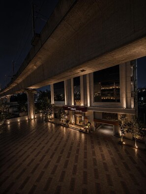 A hotel with a tiled floor, a covered outdoor area, and a sign for 'Okati Hotel by Country Club'. - Hotel Okati Begumpet (Hyderabad)