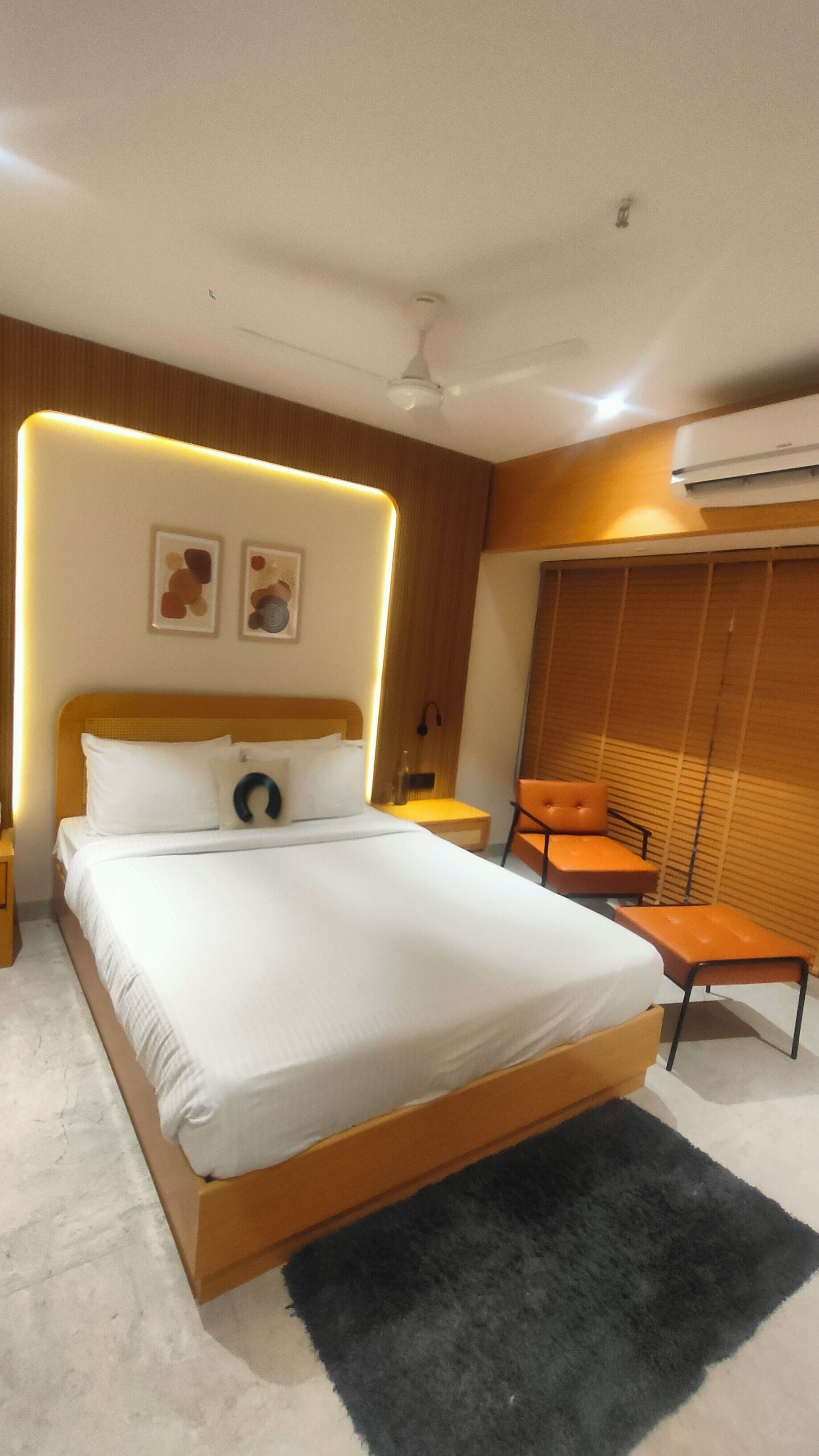 Une chambre d’hôtel moderne avec un grand lit, une petite table, une chaise et une armoire.