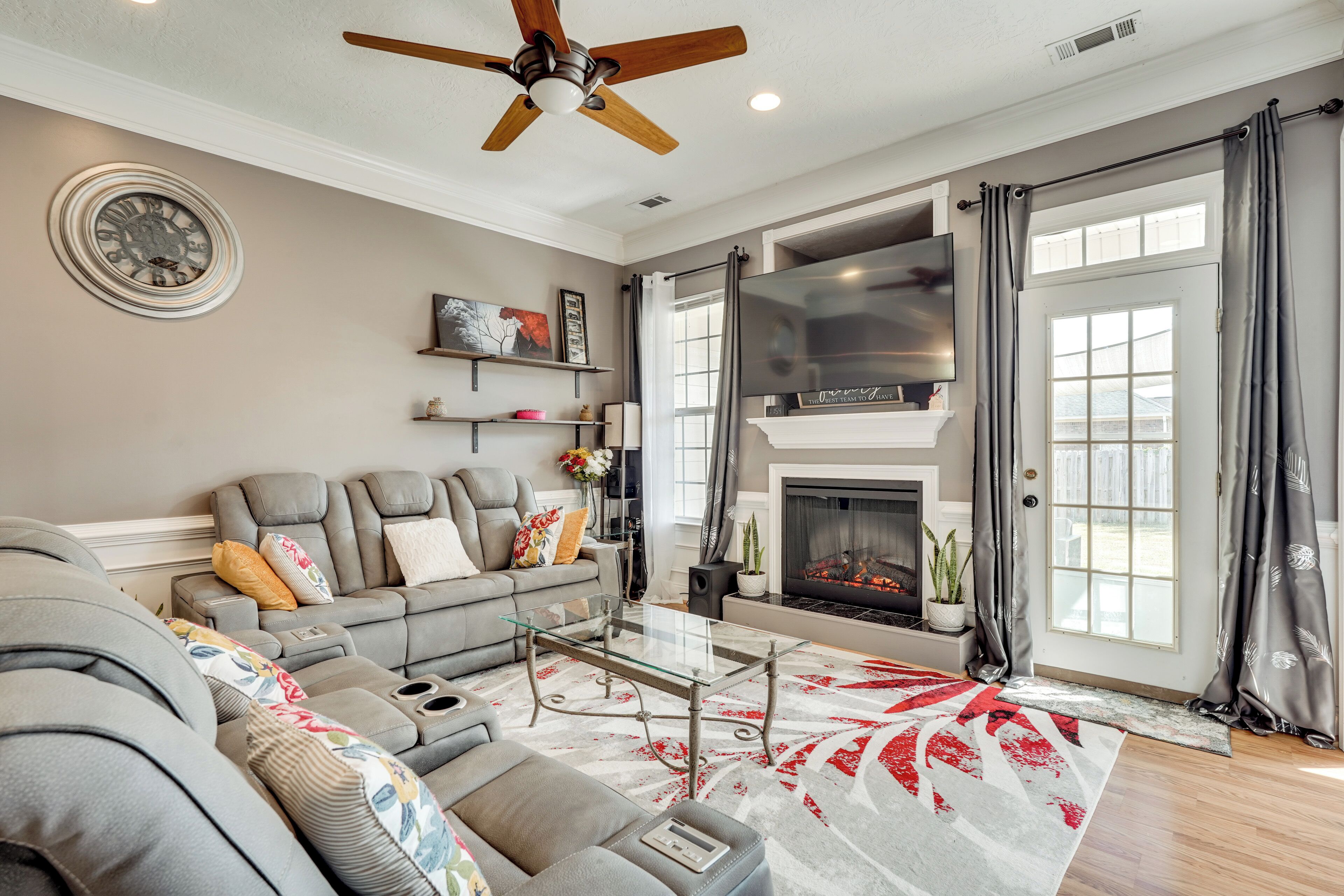 A living room with a sofa, coffee table, fireplace, and large windows.