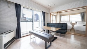 A modern hotel room with a dining table, bench, sofa, and two beds. - MOTTO (Sapporo)