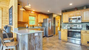 A modern kitchen with wooden cabinets, stainless steel appliances, and a central island. - Ski & Hike: Mars Hill Mountaintop Cabin w/ Views (Mars Hill)