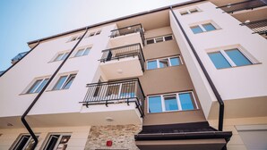 Ein mehrstöckiges Wohngebäude mit Balkonen, Fenstern und einer Ziegel-Fassade.