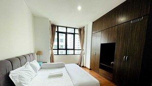 A hotel room with a bed, a TV, and a wardrobe. - Lake view Resisdence (Seri Kembangan)