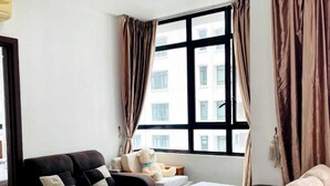 A modern living room with a sofa set, a coffee table, and a large window with curtains. - Lake view Resisdence (Seri Kembangan)