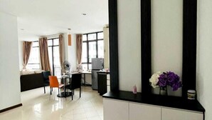 A modern hotel room with a large window, a desk, a chair, and a sofa. - Lake view Resisdence (Seri Kembangan)