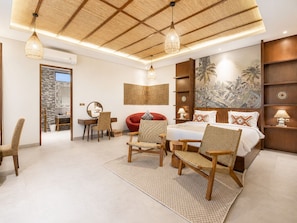 A modern bedroom with a large bed, a desk, and a chair.