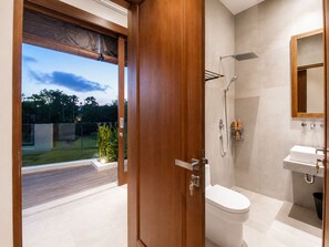 A modern bathroom with a toilet, shower, and sink. - 5BR Canggu Retreat Steps to Beach, Ricefield View (Canggu)