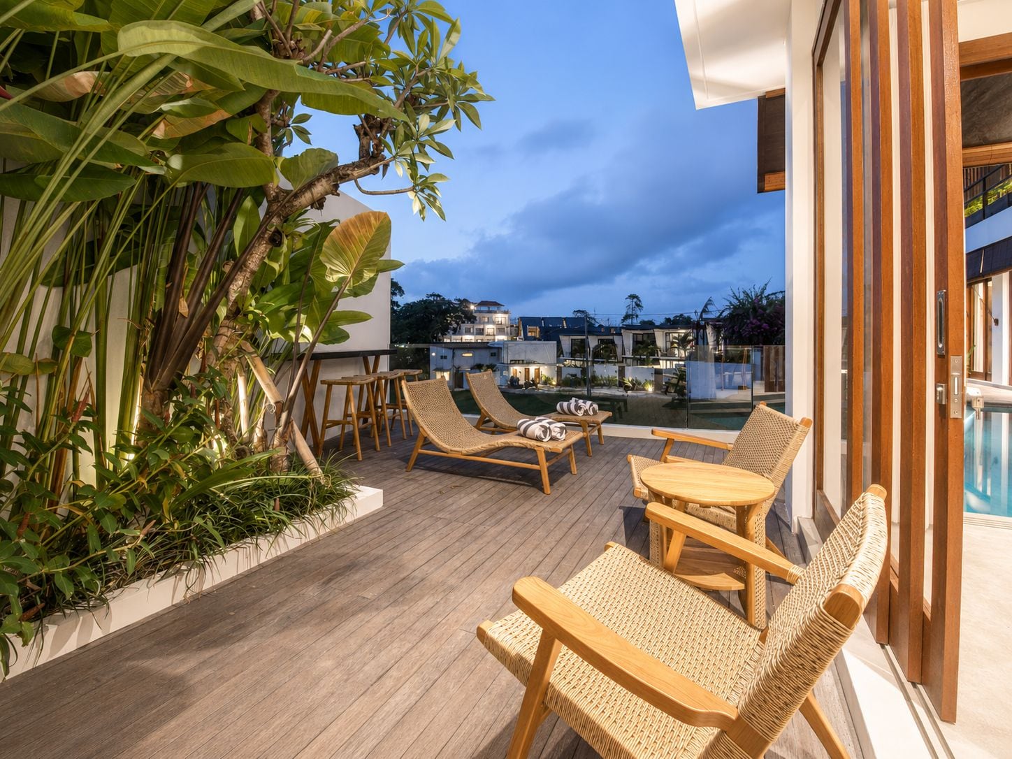 Une terrasse sur le toit, aménagée avec des meubles en bois, une piscine et une végétation luxuriante.