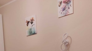 Een hotelkamer met twee bedden, elk met een beige deken en kussens. Twee opgerolde handdoeken liggen op het bed op de voorgrond.