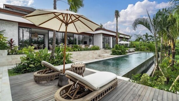 A modern resort with a pool, lounge chairs, and tropical plants. - Villa Maxime by BaliSuperHost (Bali)