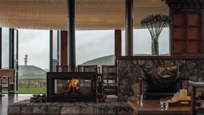 Una habitación acogedora con chimenea, pared de piedra y vistas a un faro.