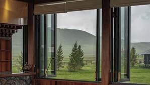 Un salón acogedor con un ventanal grande, una mesa de centro de madera y un sofá de cuero.