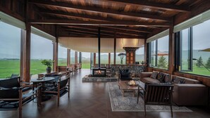 Un amplio salón con chimenea, ventanas grandes y vistas al exterior.