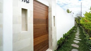 Un bâtiment moderne avec une porte en bois et le nom « Asi » inscrit sur le mur.