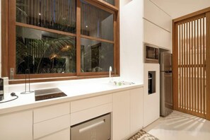 A modern kitchen with a large window, built-in appliances, and a sliding door.
