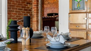 A dining table set with plates, glasses, and a black candle. - Orchard Cottage—A Leafy Peaceful Retreat with Spa (Lenswood)
