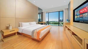 A modern hotel room with a large bed, a TV, a desk, and a view of the city. - Xilaideng Guangzhou Service Apartment (Guangzhou)
