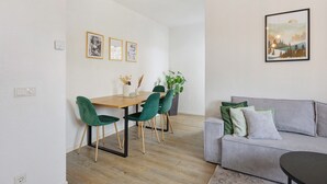 Un salon moderne comprenant un coin repas, un canapé et un tableau accroché au mur.