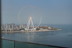 A large Ferris wheel with a modern cityscape in the background.