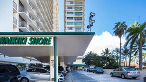 A parking area in front of Makiki Shore with several cars parked.