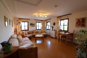 Un salon comprenant un canapé, une table basse, une table à manger avec des chaises et un radiateur.