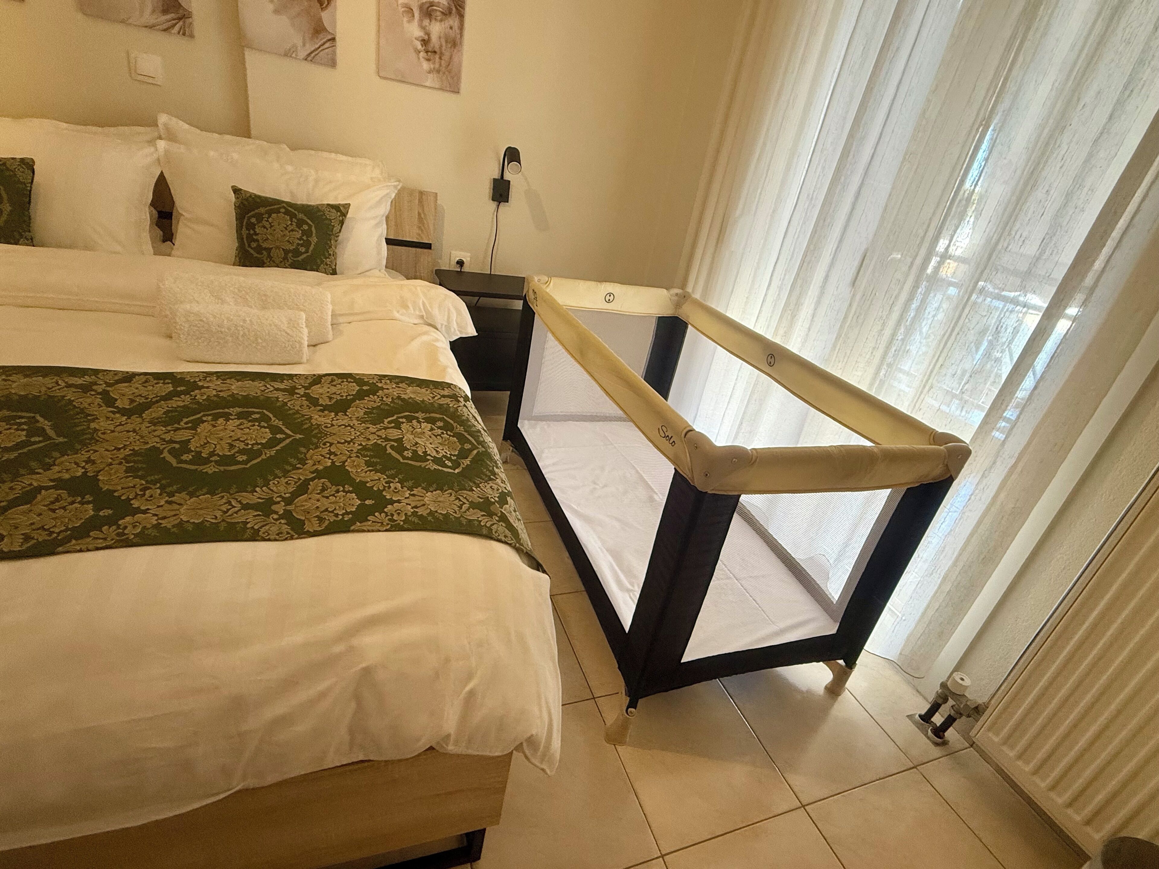 A hotel room with a bed, a nightstand, a window with curtains, and a view of the outside.
