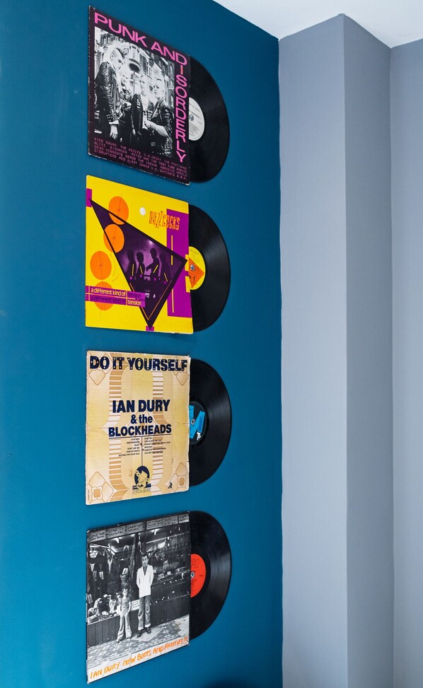 A wall with vinyl records and their covers displayed vertically. - Starbeck Micro Hotel (Harrogate)