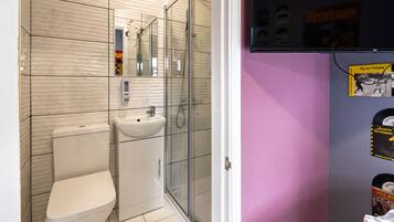 A bathroom with a toilet, sink, and glass shower enclosure.