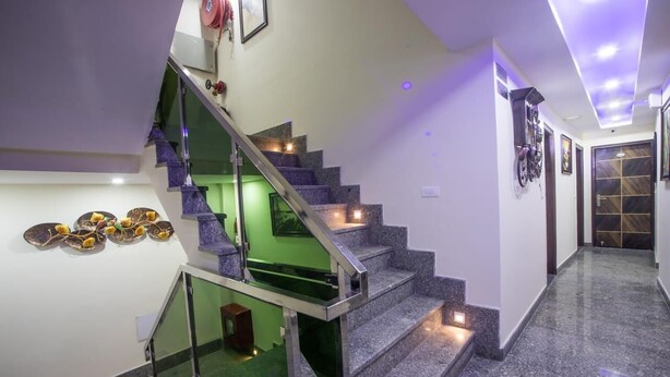 Un escalier moderne avec des rampes en verre et un mur d’accent de couleur verte.