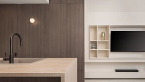 A modern kitchen with a built-in sink and a flat-screen TV mounted on the wall. - Glyfada Prime Apartment, Glyfada Prime Living (Athens)