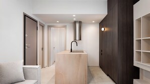 A modern kitchen with a central island, dark wood cabinetry, and recessed lighting. - Glyfada Prime Apartment, Glyfada Prime Living (Athens)