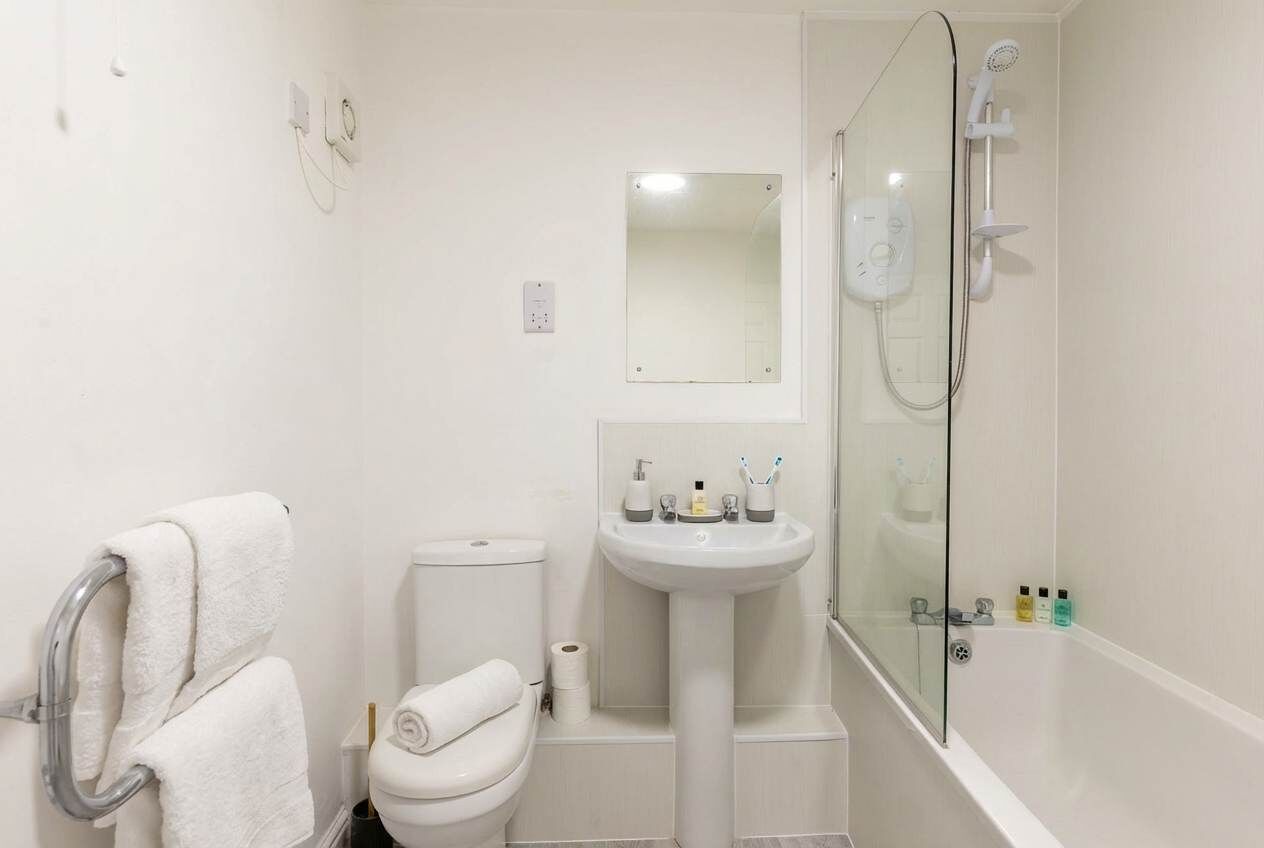 Une salle de bain avec des toilettes, un lavabo et une douche.