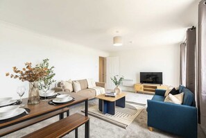 Un salon moderne avec un canapé, une table basse et un coin repas.