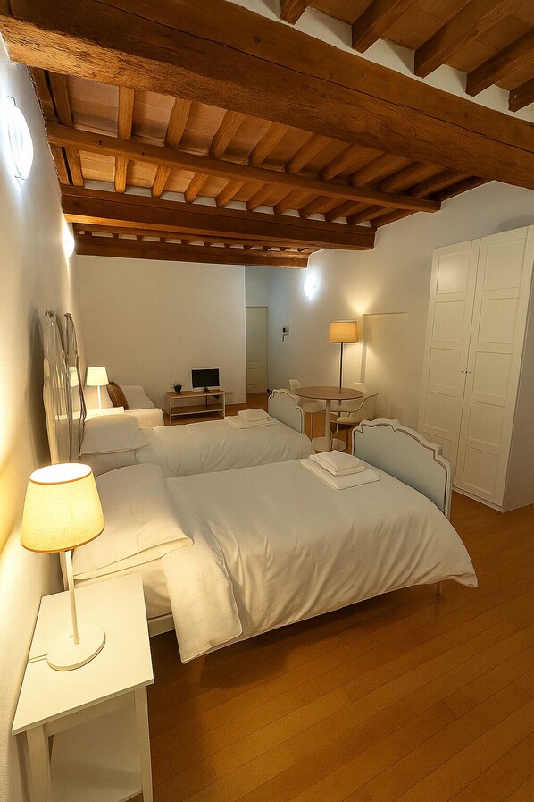 A bedroom with two beds, a desk, a chair, a lamp, and a wardrobe. - Appartamento Ferraresi (San Felice sul Panaro)