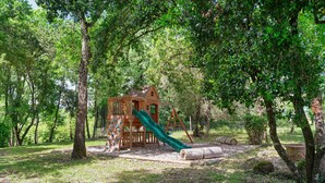 A wooden play structure with a slide, surrounded by trees. - Guest Room 'Domaine du chemin Royale' with Shared Terrace, Shared Garden, and Wi-Fi (Saint-Germain)