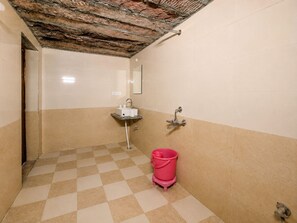 A bathroom with a checkered floor, a sink, a mirror, and a red bucket. - The Royal Sam Desert Camp (Jaisalmer)