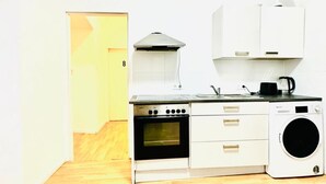 Cocina compacta equipada con estufa, horno, microondas y lavadora.
