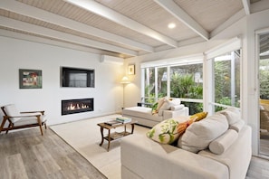 Una sala de estar moderna con chimenea, un sofá, una silla y una mesita de centro.