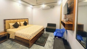 Ein Schlafzimmer mit einem hölzernen Bett, einem Flachbildfernseher, einem kleinen Schreibtisch und einem Spiegel.