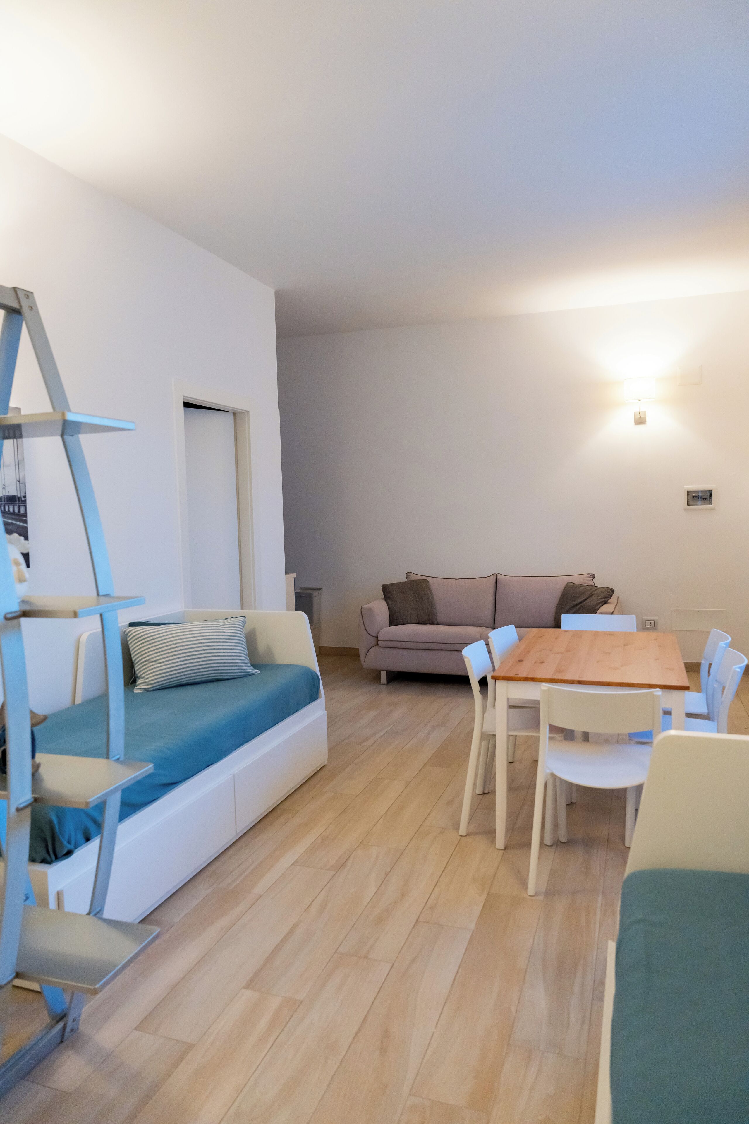 Ein modernes Wohnzimmer mit einer Couch, einem Esstisch und einer Treppe.