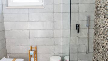 Un baño moderno con ducha, inodoro y bañera.