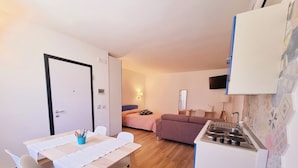 Ein kompakter Wohnraum mit Küchenzeile, Essbereich und Schlafzimmer.