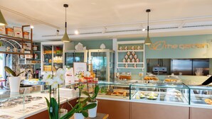 Eine Bäckerei mit Glastheken, Regalen voller Backwaren und einem Schild mit der Aufschrift 'The Garden'.