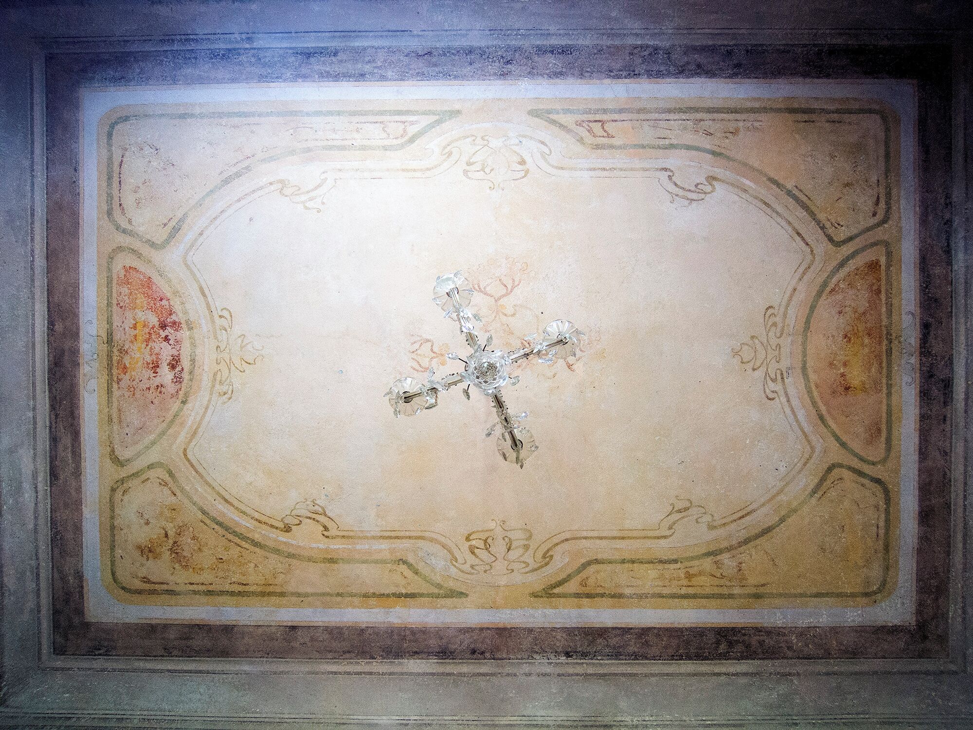 A ceiling with a decorative cross design and ornate moldings.