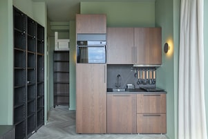 A compact kitchen with built-in appliances, a sink, and a stove.