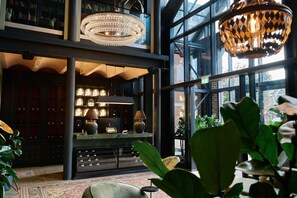 A spacious lobby with a grand chandelier, a large window with a view of the outside, and a reception desk with a modern design. - The Hill by Nestor (Harrow)