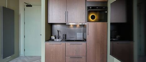 A compact kitchen with a built-in oven, a microwave, and a sink.