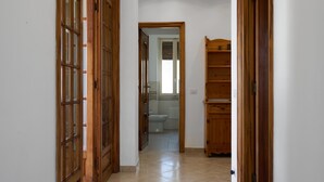 A hallway with wooden doors and a tiled floor, leading to a bathroom. - Villa Camilla App Garden (Diano Castello)