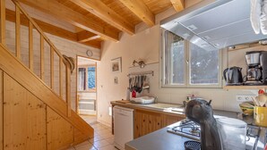 A kitchen with wooden beams, a coffee maker, and a sink. - Gîte Madres Coronat Balcon du Canigou (Jujols)